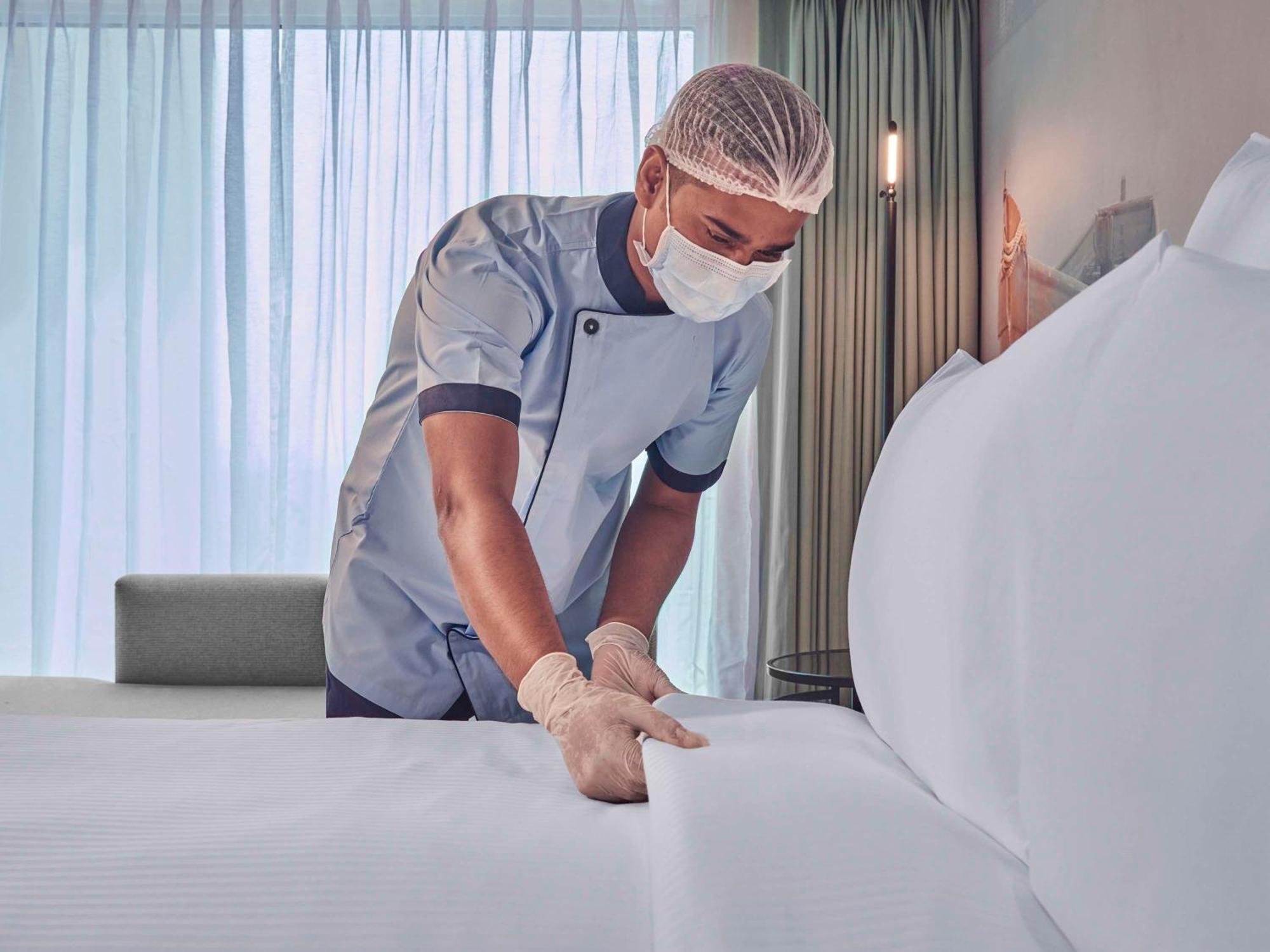 Novotel Mumbai International Airport Esterno foto A hotel housekeeper making a bed
