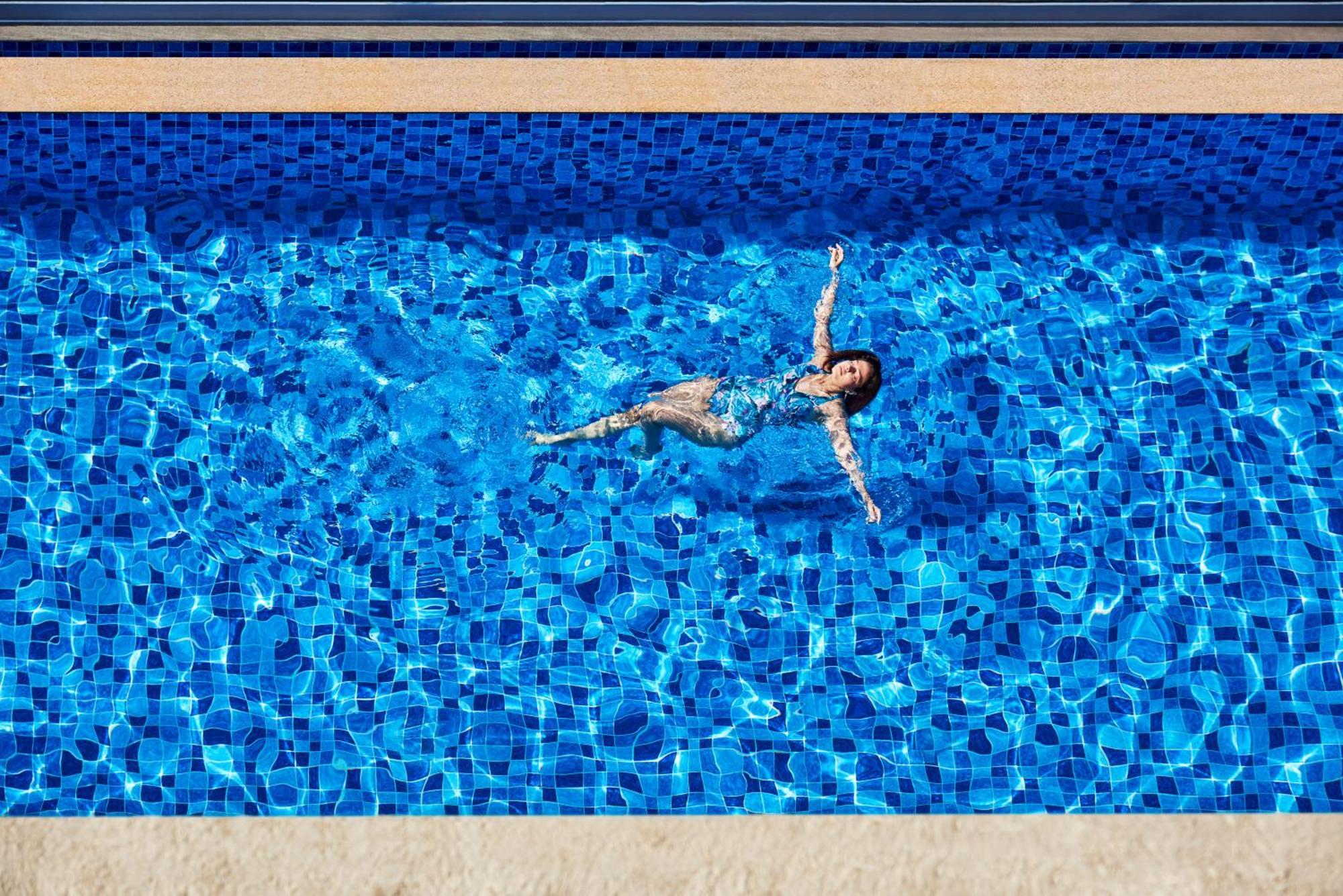 Novotel Mumbai International Airport Esterno foto A woman floating in a swimming pool