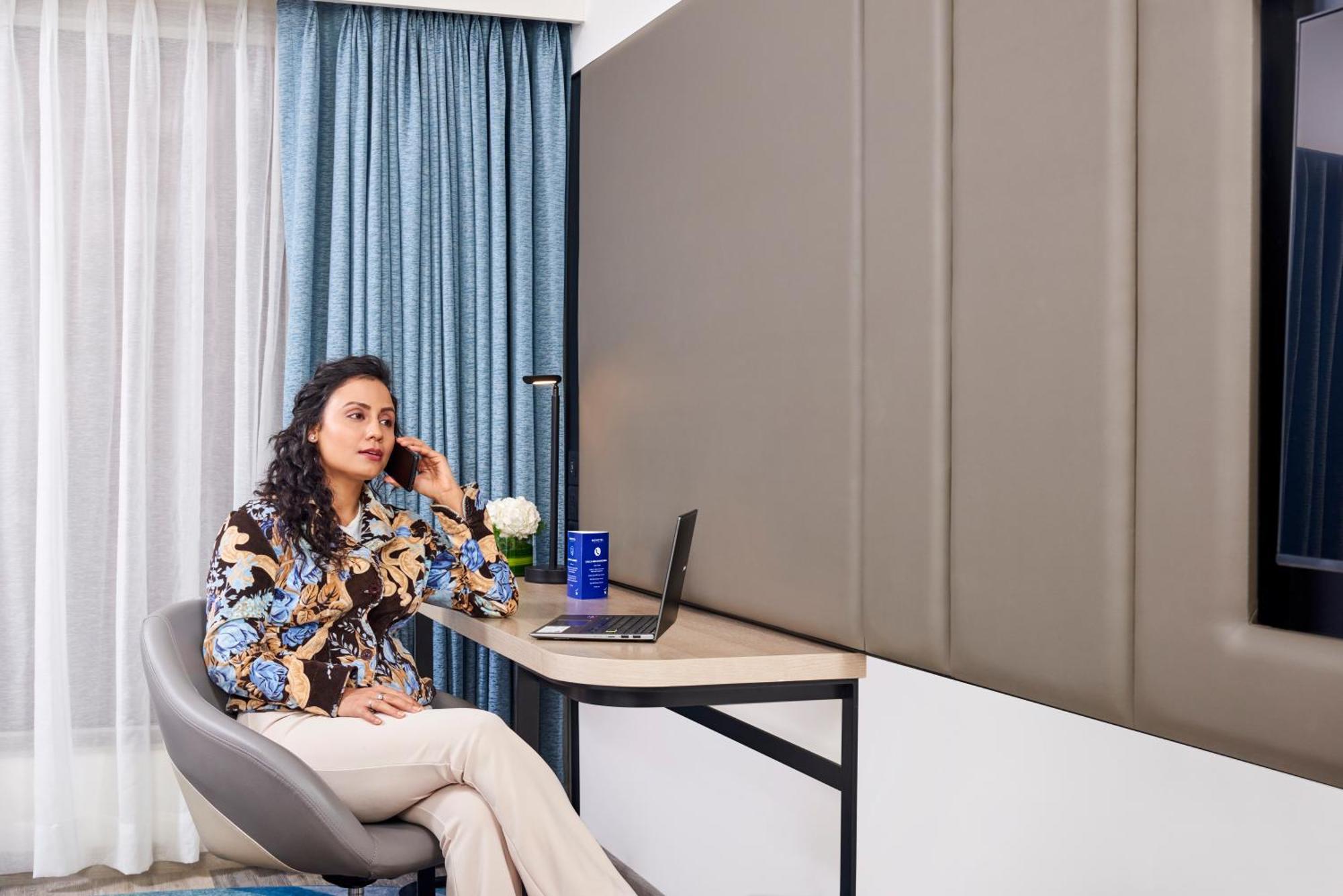 Novotel Mumbai International Airport Esterno foto A woman working from home